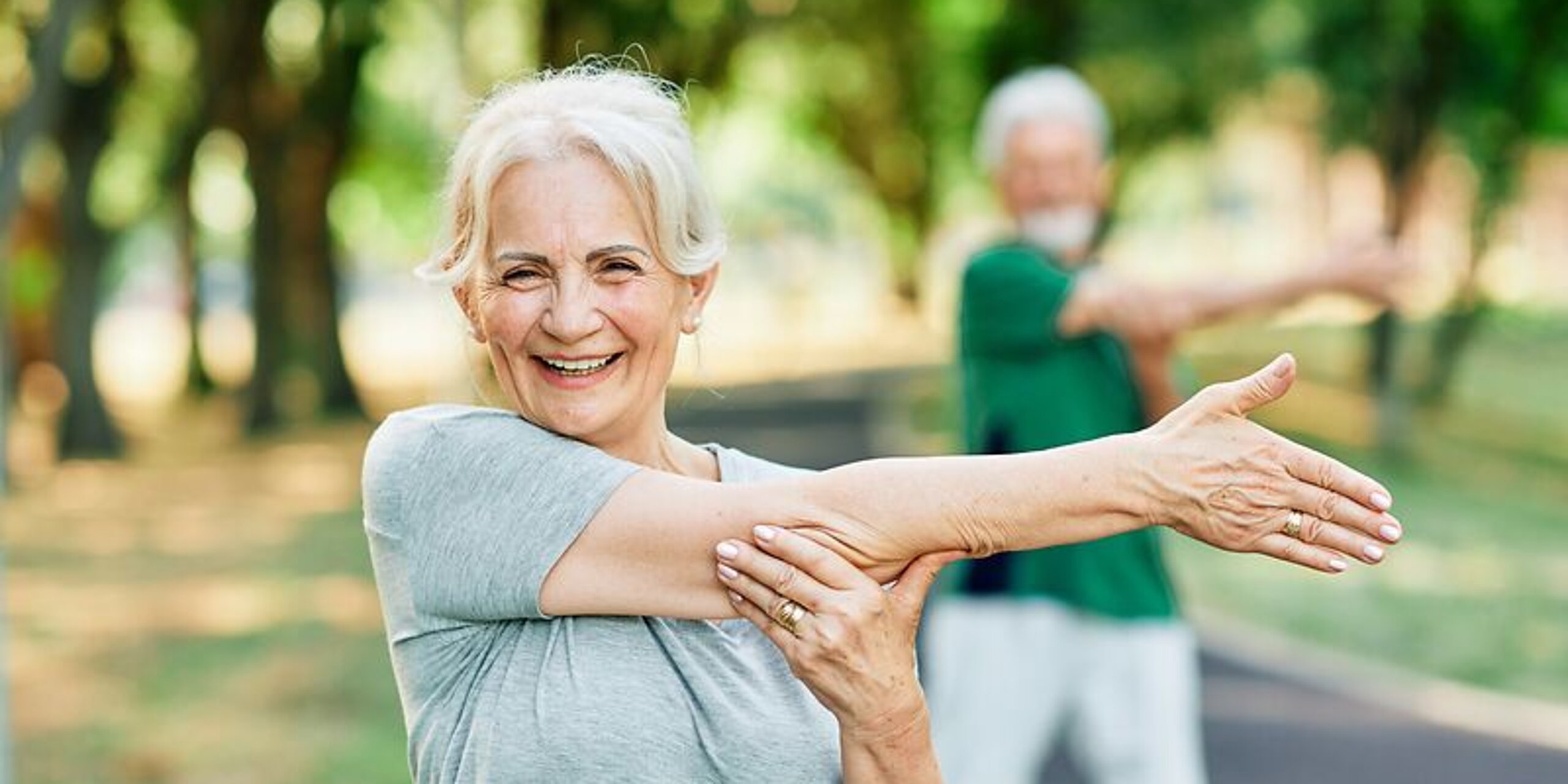 Frau macht Dehnübungen im Park.